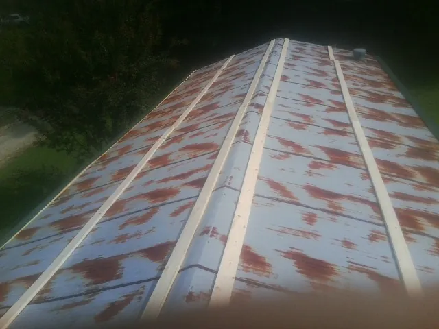 Rusted metal roof panels with new wood purlins before replacement — Storm Damage Roof Repair in Holden by Roofing Brothers