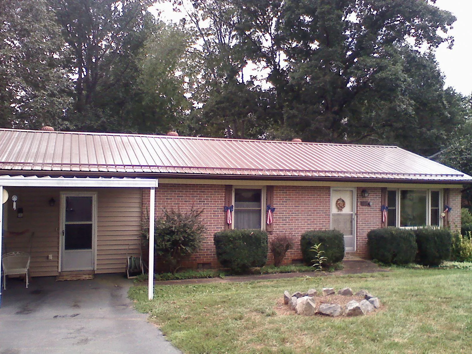 Bronze metal roof and carport on a brick ranch home — Roof Repair work by our crew in Holden